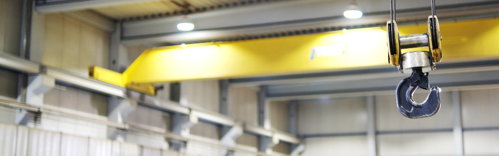 Nahaufnahme eines Kranhakens mit gelben Bauelementen